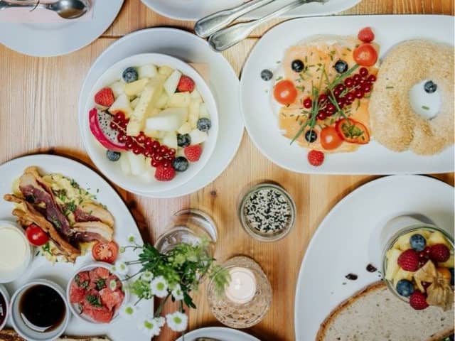Gedeckter Brunchtisch von oben mit mehreren Tellern