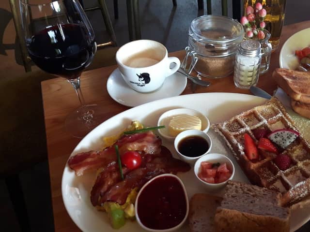 Frühstücksteller mit Waffel, Bacon und Cappuccino